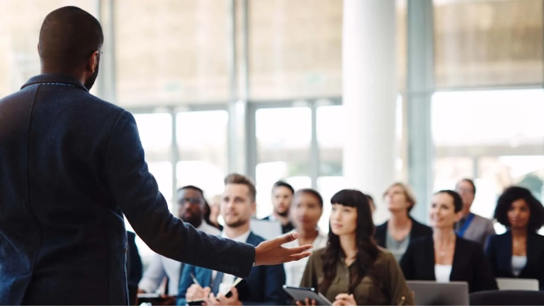 Google Ads Micro Audience Professional speaker presenting to a diverse business audience in a modern conference room.